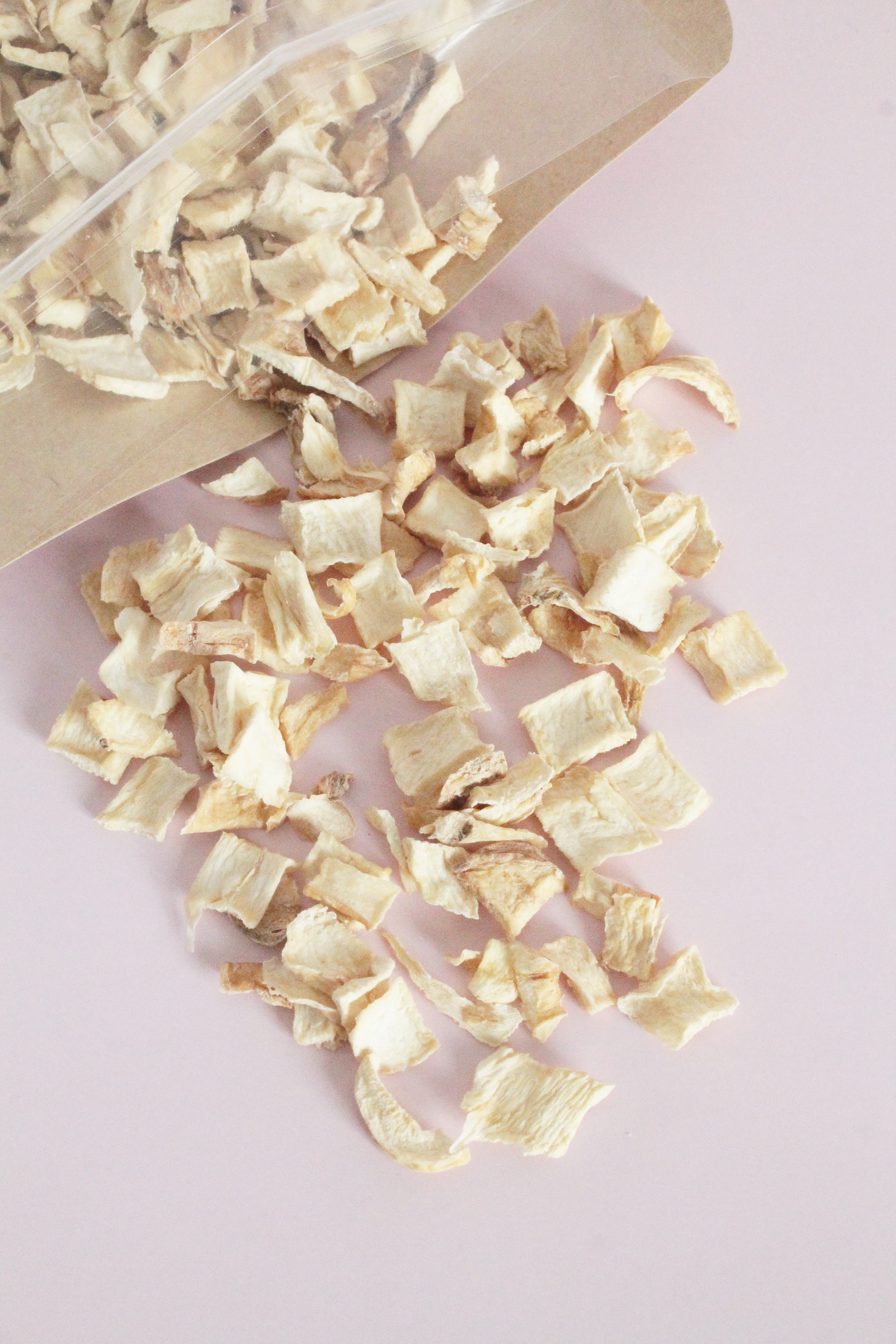 Dried herbs or similar product on a pink background