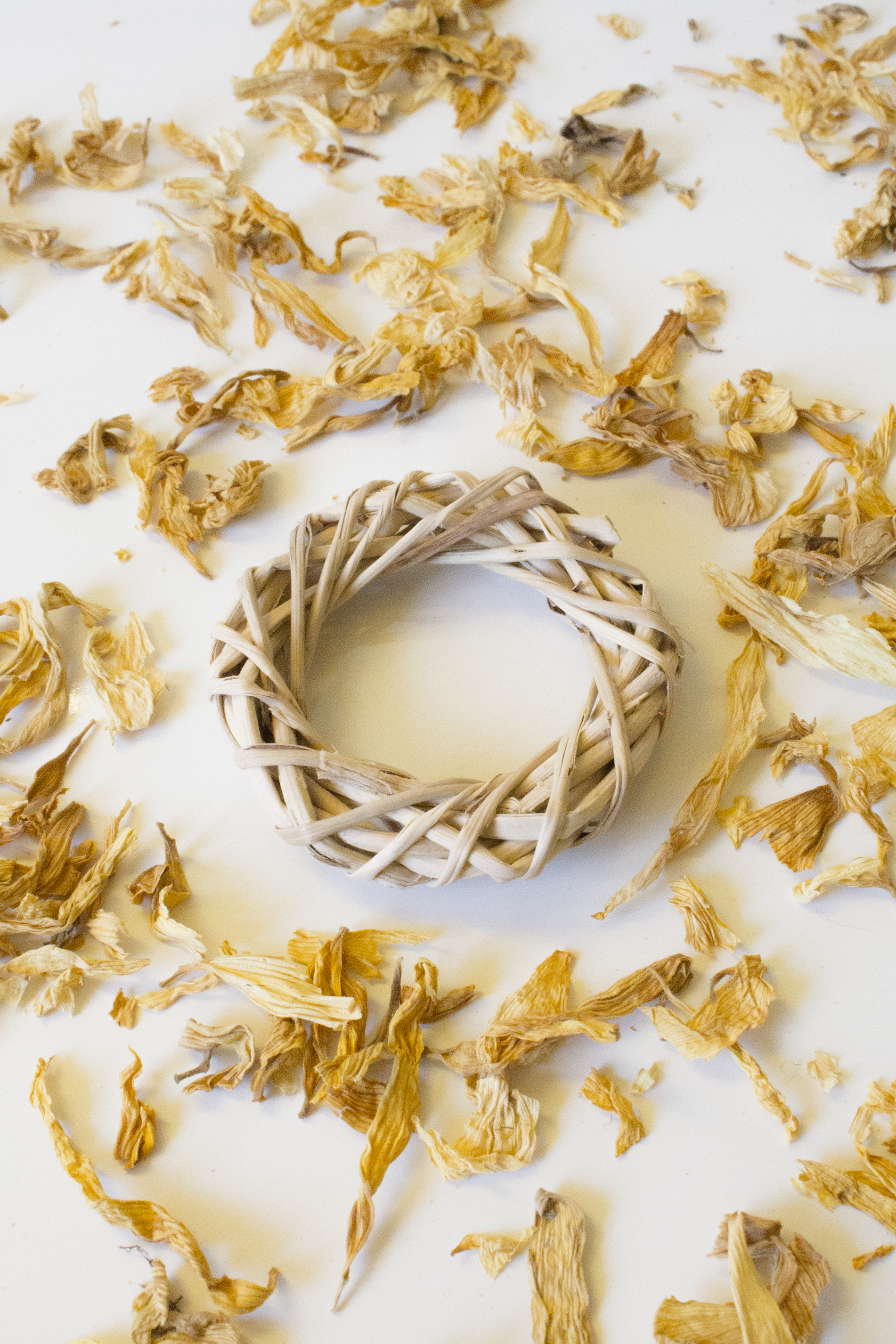 Wicker ring with dried yellow flowers on a white background