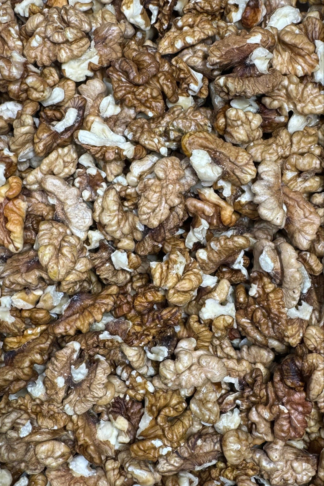 A close-up of Moony Paw walnuts, showing their rich brown color and textured, irregularly shaped pieces.