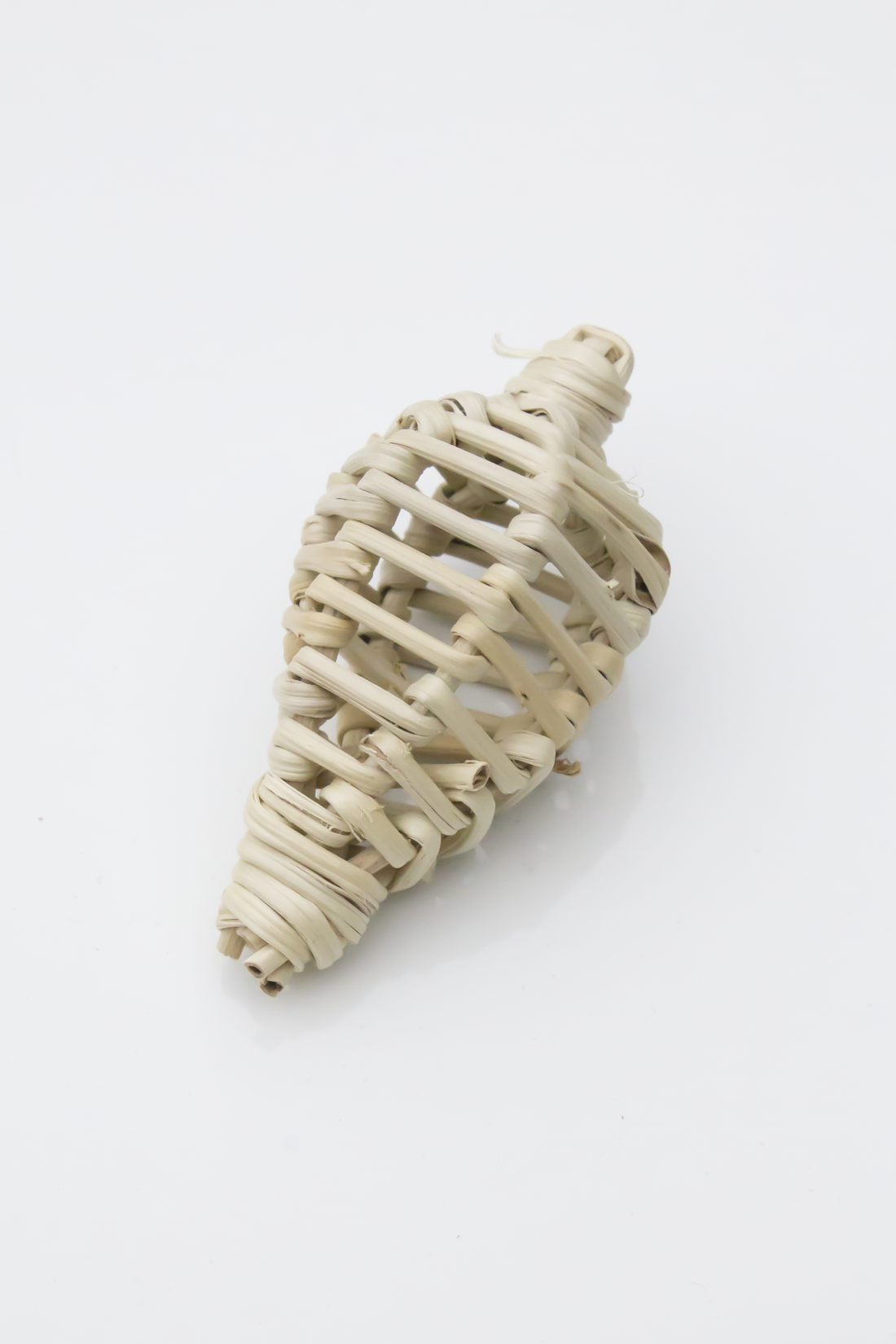 Woven beige shell-shaped decorative item on a white background